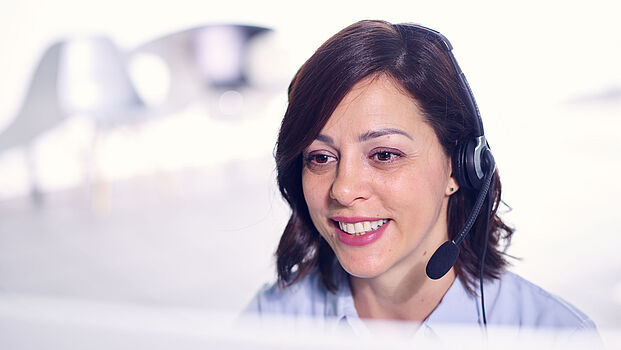 Support Mitarbeiterin von ibo am Arbeitsplatz mit Headset