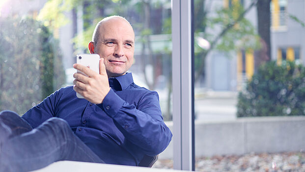 Mitarbeiter von ibo am arbeiten im Büro mit dem Smartphone